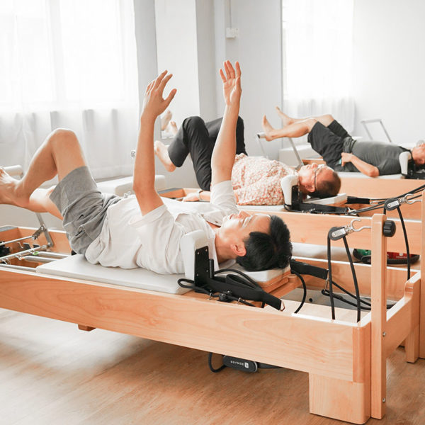 Three men in their 50's doing a Beginners Reformer Pilates class at Body in Common Bangsar